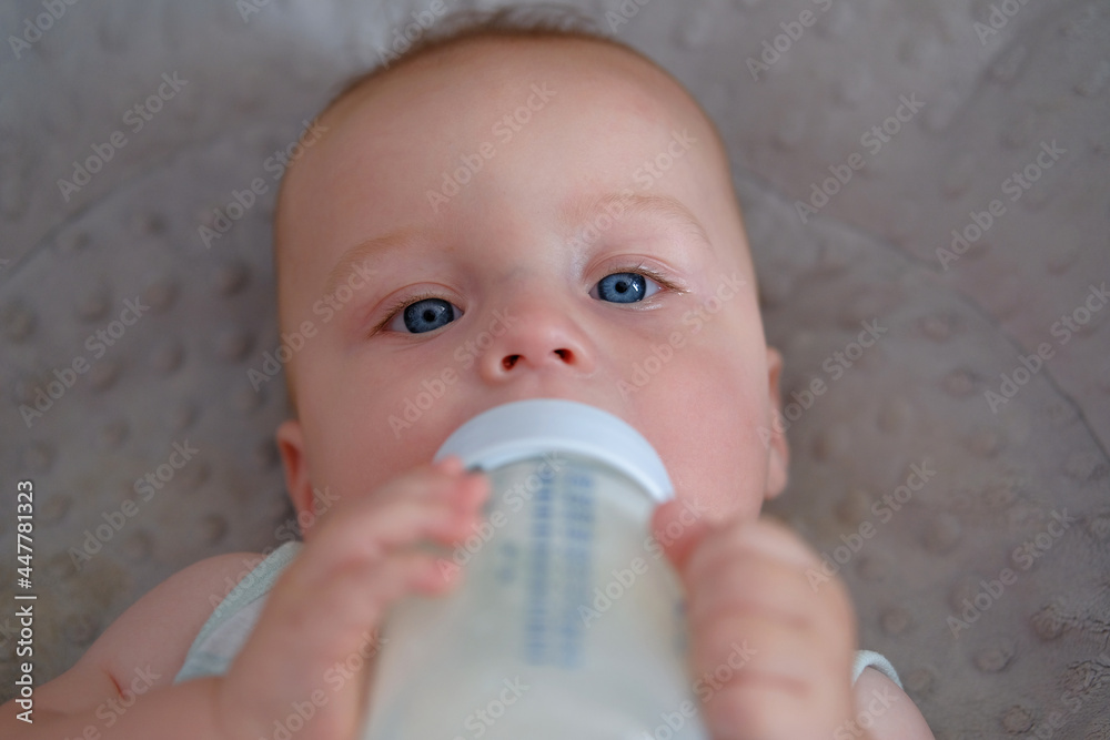 portrait of a cute baby boy drinking milk from a bottle portrait of a cute baby boy drinking milk from a bottle