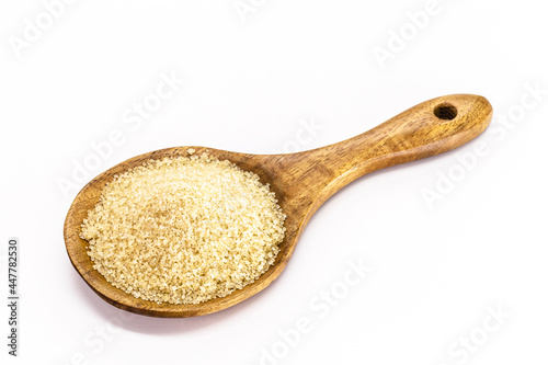 wooden spoon with raw sugar, demerara sugar, isolated white background with copyspace