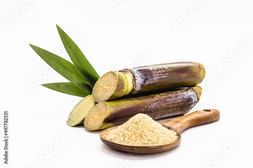 wooden spoon with unrefined raw cane sugar, demerara sugar, with sugar cane, isolated white background with copyspace