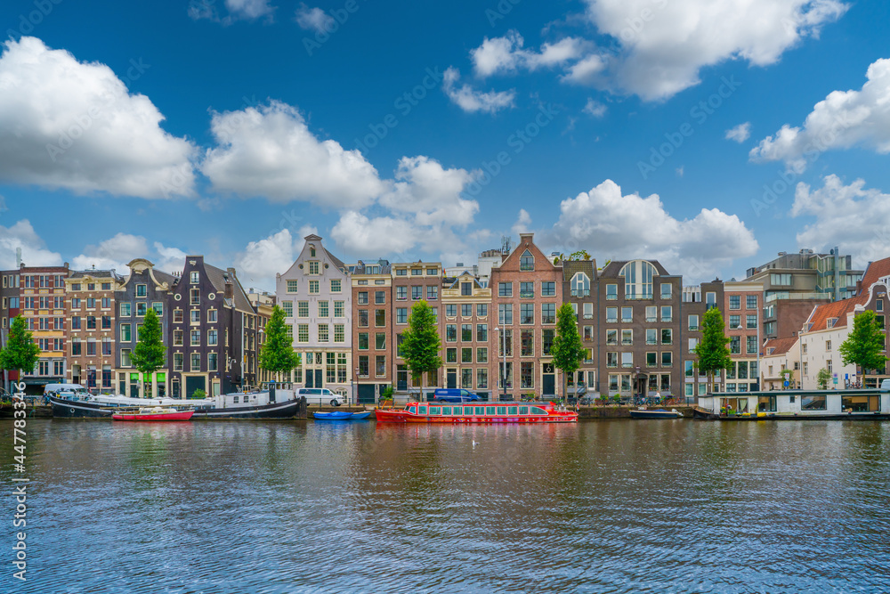 Obraz premium Amsterdam, The Netherlands 23th June 2021 -Taxi boar filled with tourists waiting to sail off on the Amstel River in Amsterdam during summer