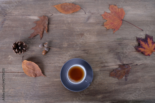 beverage, hot drink in a mug, leaves, foliage, garland, candles, top view of wooden table, good weather concept, outdoor tea party, cozy autumn mood