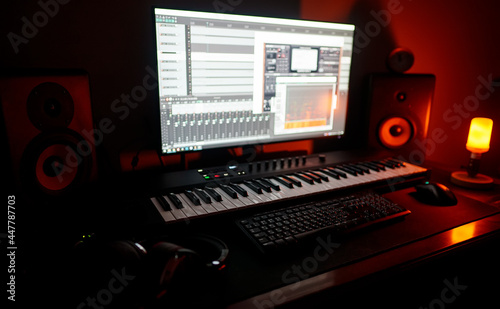 Recording studio with professional monitors and midi keyboard.