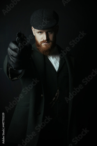 A Victorian man wearing a tweed suit and holding a gun