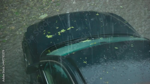 Top view shows front of a black car drained and stuck in a heavy rain and hail storm, Natural disaster effect on vehicle in flood bad weather concept.