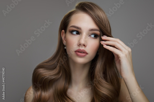 Portrait of a beautiful brunette woman with long wavy hair. Copycpase