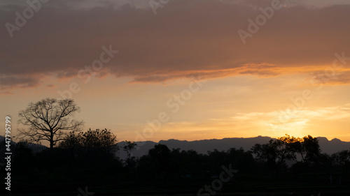 The sunset behind the hill, looks warm and calm with a rural atmosphere