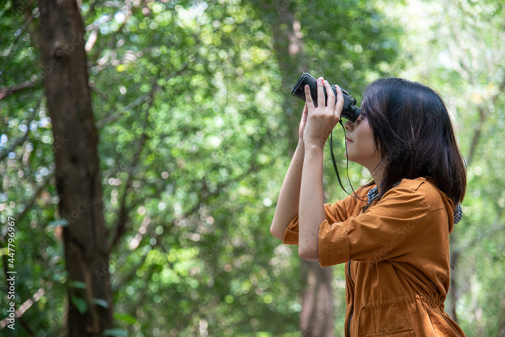 Asian woman use binoculars for a bird watching or a beautiful view
