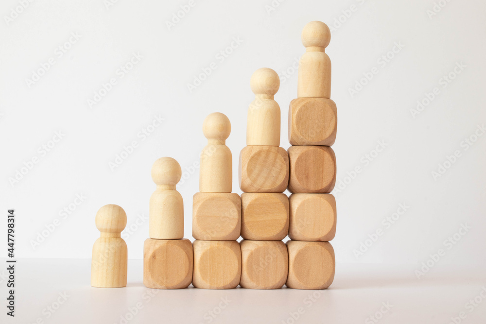 silhouette of an office worker with a suitcase climbs the stairs. gears on a wooden background. silhouette of an office worker with a suitcase climbs the stairs. gears on a wooden background.