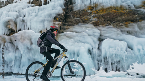 Bild auf Leinwand Man is riding bicycle near ice grotto