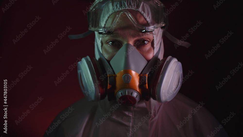 Man in protective costume suit, gas protect medical antibacterial antiviral spray paint mask. Doctor health worker in respirator. Concept health virus coronavirus epidemic. Radiation Nuclear war. Man in protective costume suit, gas protect medical antibacterial antiviral spray paint mask. Doctor health worker in respirator. Concept health virus coronavirus epidemic. Radiation Nuclear war.