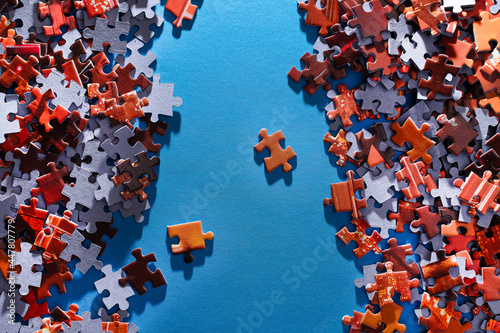 Mixed Peaces of a Colorful Jigsaw Puzzle Lie on the Blue Background - Strategy and Solving Problem Concept