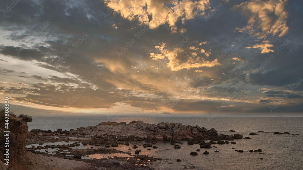 Obraz premium sea cliffs at sunset, reflection of mountain and sea