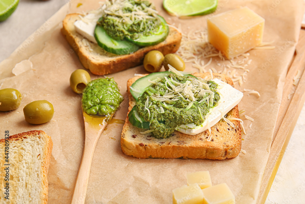 Tasty toasts with pesto sauce and olives on table, closeup