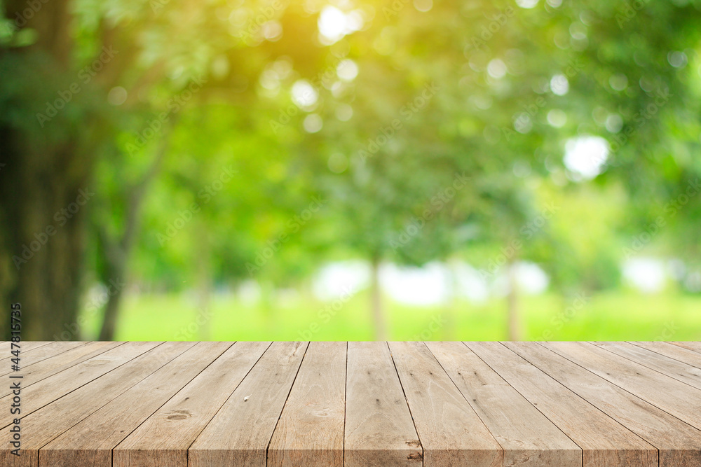 Wood floor with blurred trees of nature park background and summer season, product display montage Wood floor with blurred trees of nature park background and summer season, product display montage