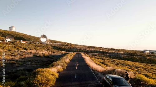 Slowly following overhead a runner on the road in front of  the Roque de los Muchachos Observatory on the island of La Palma in the Canary Islands photo