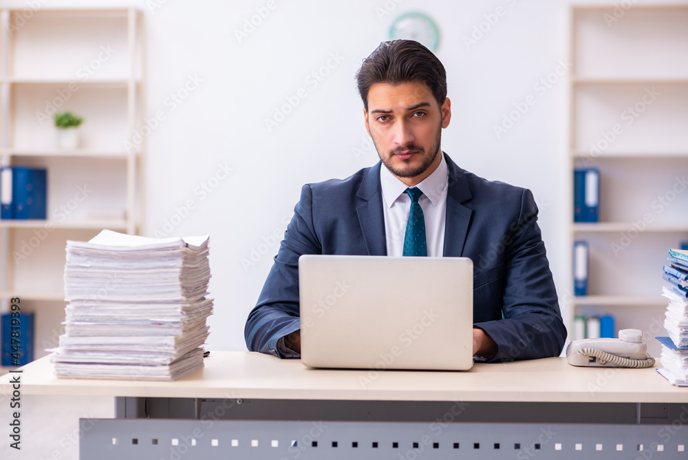 Young businessman employee and too much work in the office Young businessman employee and too much work in the office