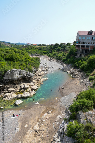 Spielende Kinder baden im Fluss Kir an der Ura e Mesit in Skhodra Albanien, albanischer Sommer mit blauem Himmel photo