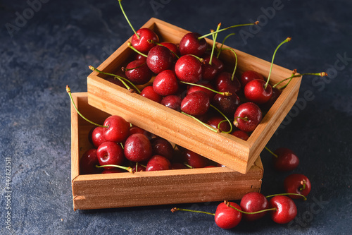 Boxes with sweet cherry on dark background
