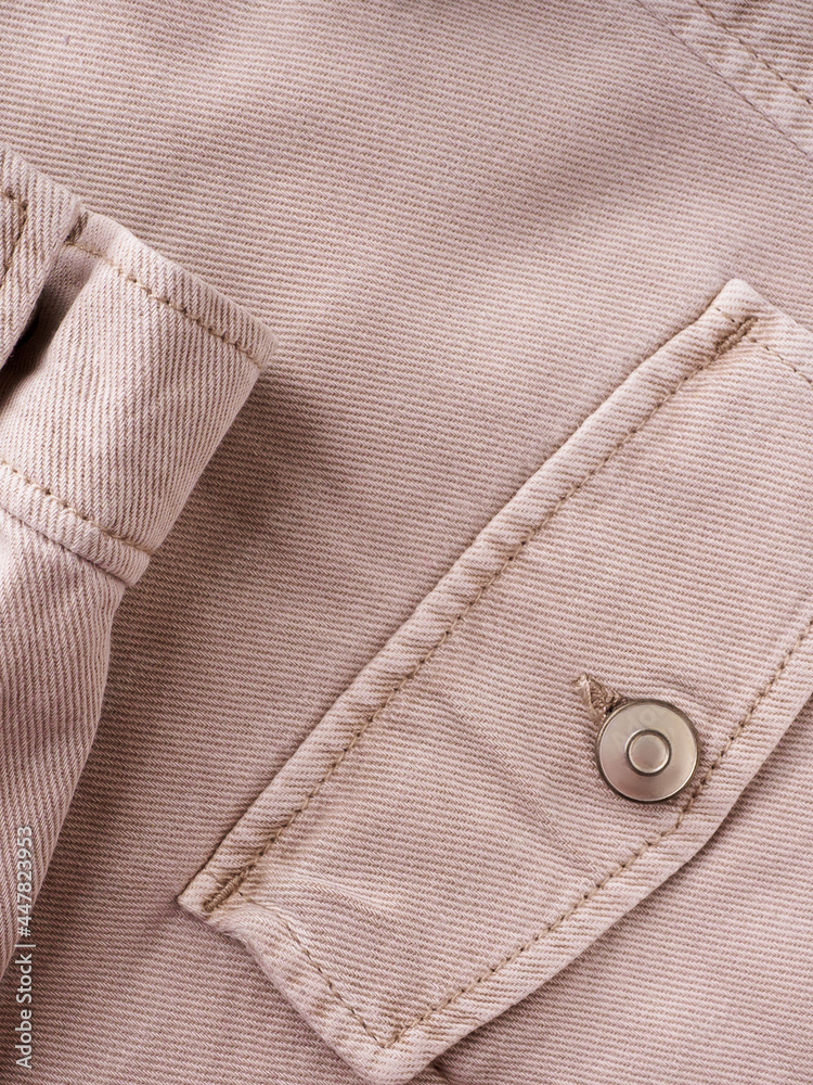 Elements of tailoring a denim beige shirt close-up. Pockets, buttons, and sleeves on a denim shirt. Modern comfortable denim clothing concept Elements of tailoring a denim beige shirt close-up. Pockets, buttons, and sleeves on a denim shirt. Modern comfortable denim clothing concept
