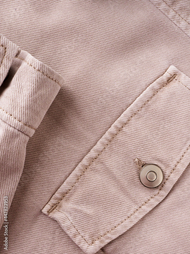 Elements of tailoring a denim beige shirt close-up. Pockets, buttons, and sleeves on a denim shirt. Modern comfortable denim clothing concept