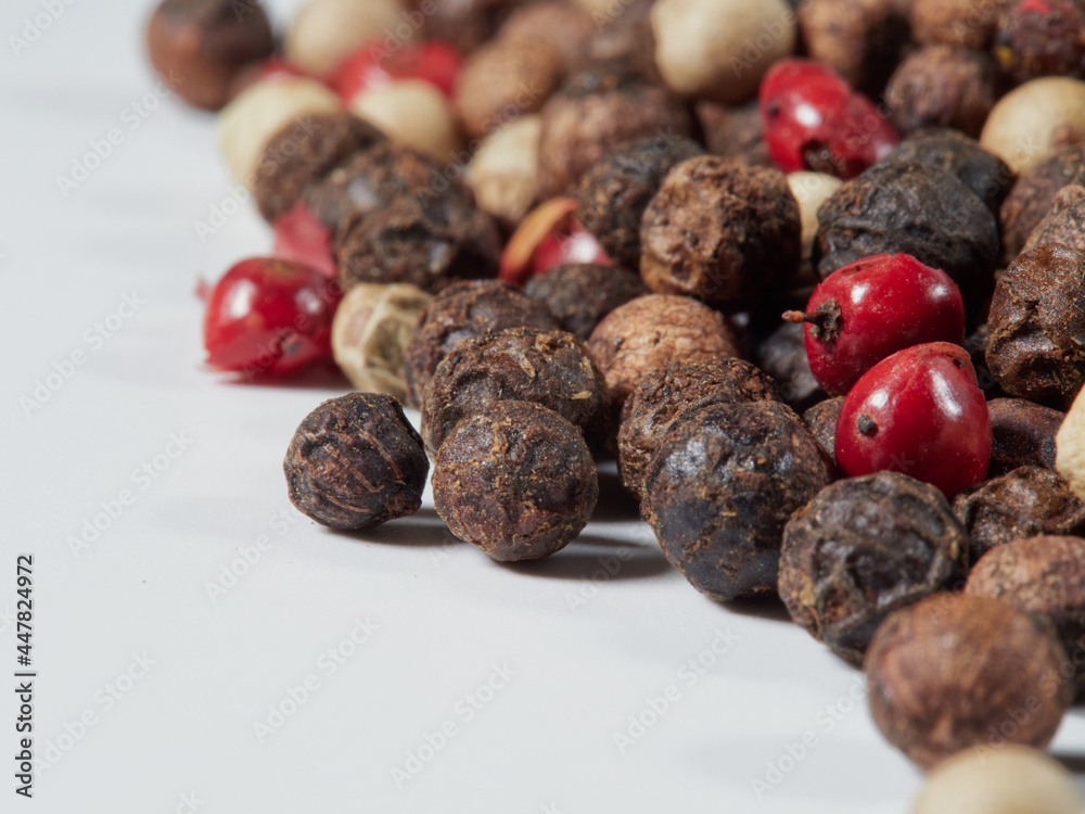Obraz premium Close-up image of black pepper on a white background, the view above