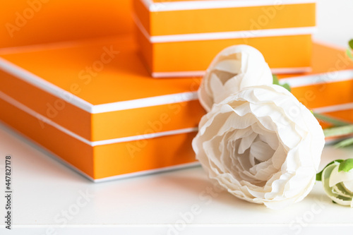 Close up of DYellow boxes with peony flower on the table. Making gift concept. photo