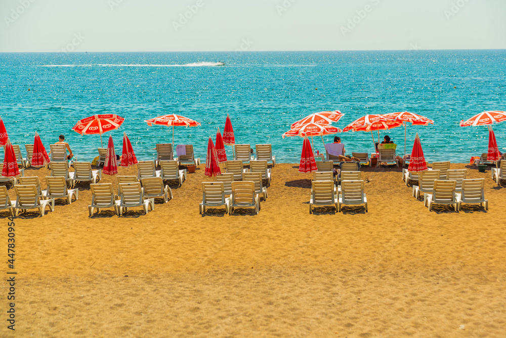 ANTALYA, TURKEY: Sun loungers and umbrellas on the Lara beach on a sunny summer day in Antalya. ANTALYA, TURKEY: Sun loungers and umbrellas on the Lara beach on a sunny summer day in Antalya.
