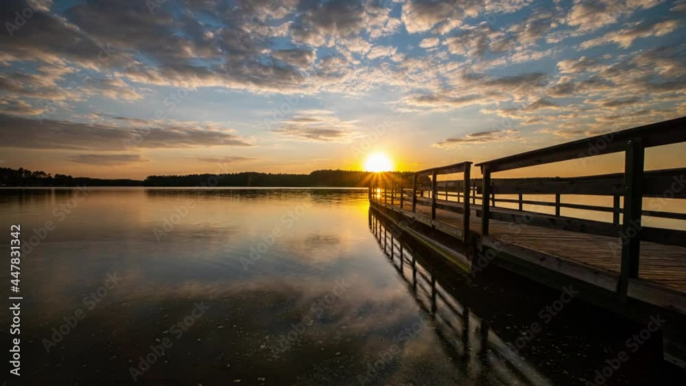 Sunset Over Lake Time Lapse. Clouds Reflecting in Calm Water. Colorful Sunset Sky. Lake Wdzydze, Kashubia,Poland Sunset Over Lake Time Lapse. Clouds Reflecting in Calm Water. Colorful Sunset Sky. Lake Wdzydze, Kashubia,Poland