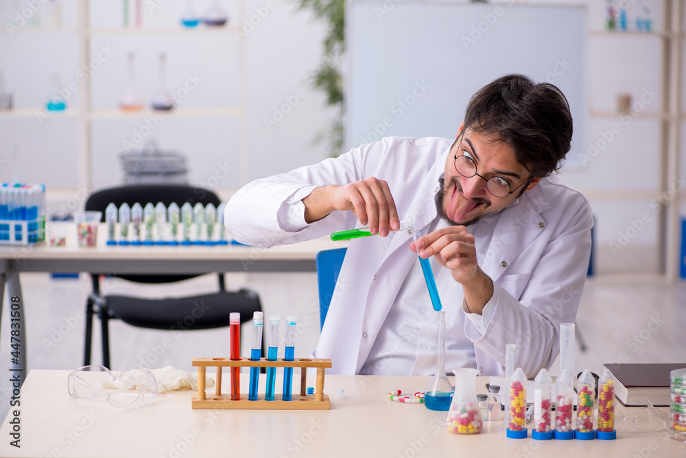 Young male chemist in drugs synthesis concept Young male chemist in drugs synthesis concept