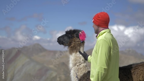 Male model and llama, lama glama, in the new rainbow Mountains, seven color mountains in Cusco, Peru. photo