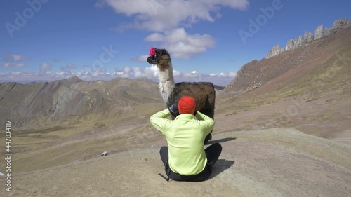 Clip of male model and llama with the seven color rainbow Mountains in the andes of Cusco, Peru photo