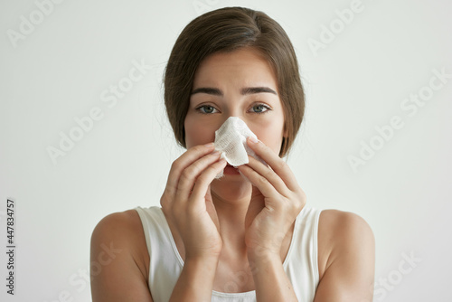 sick woman in white tank top handkerchief runny nose health problems cold flu