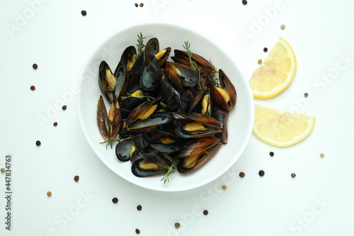 Plate with fresh mussels on white background