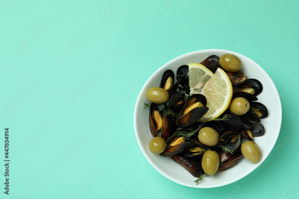 Bowl of mussels with spices on mint background Bowl of mussels with spices on mint background