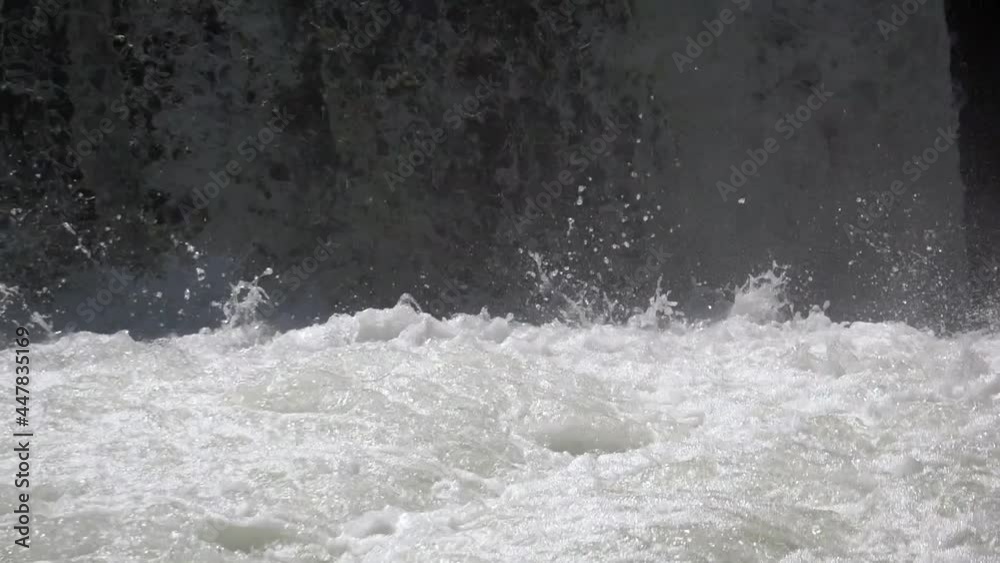Slow motion shot of crashing and splashing waterfall during sunny day in swiss alp mountains Slow motion shot of crashing and splashing waterfall during sunny day in swiss alp mountains