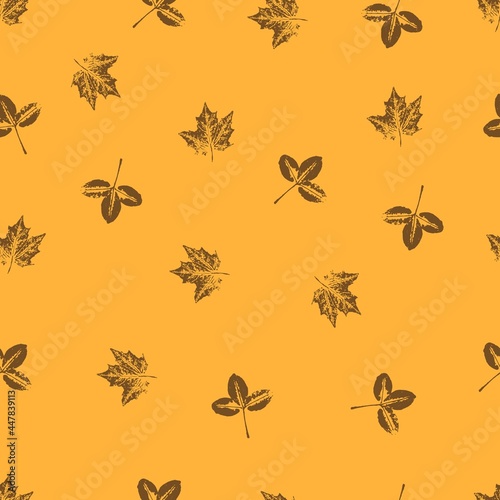  seamless pattern with delicate leaves on a mustard yellow background. Vector grunge leaf print. Printing on fabric, wallpaper, packaging, stylization under a stamp or an imprint of summer leaves  © Olga Mykovych