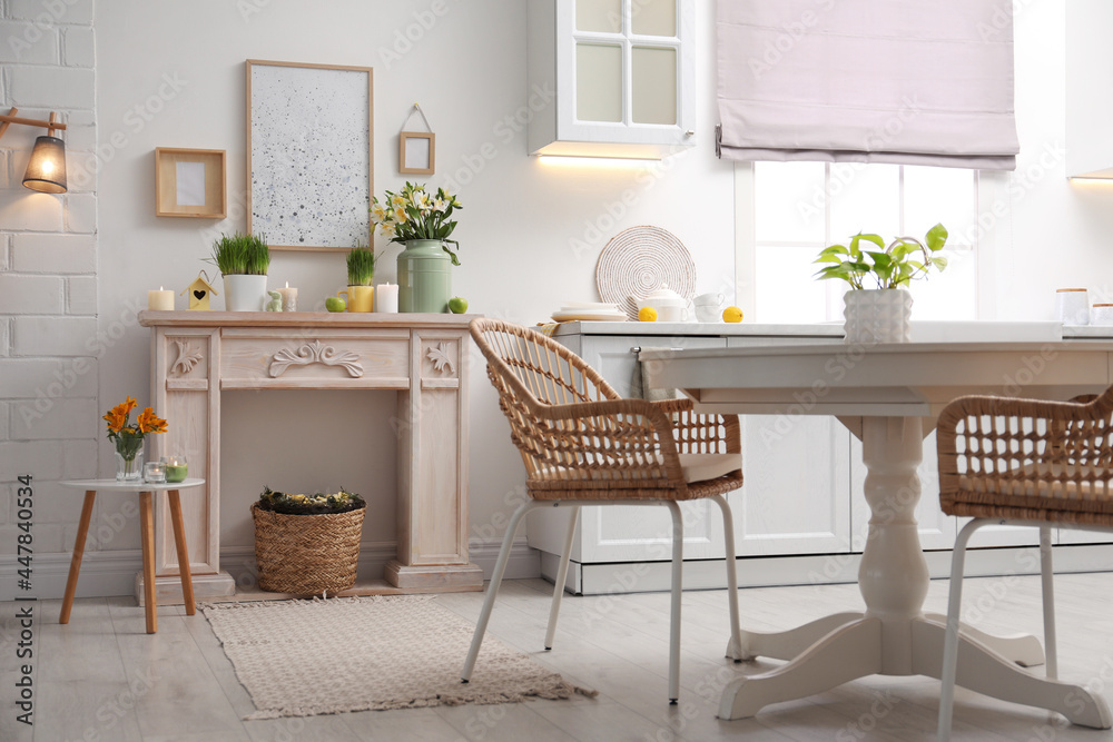 Fototapeta premium Decorative fireplace with beautiful spring flowers indoors. Interior design