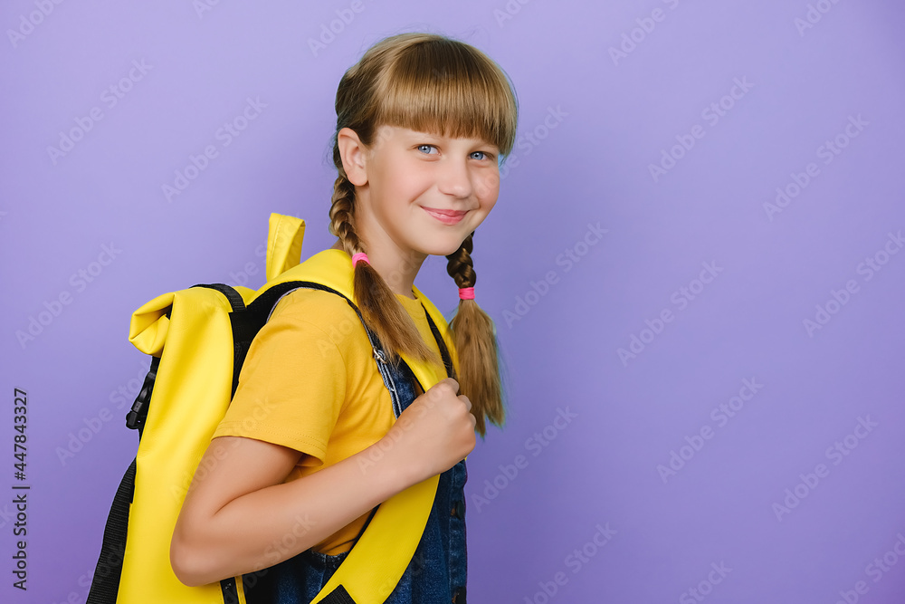 Close up portrait of happy smiling preteen girl, caucasian kid schoolgirl holding yellow backpack standing isolated on lilac violet background, positive looking at camera, back to school concept Close up portrait of happy smiling preteen girl, caucasian kid schoolgirl holding yellow backpack standing isolated on lilac violet background, positive looking at camera, back to school concept