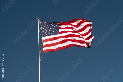 Flag of the USA is waving on blue sky background. National symbol of the United States of America  independence  patriotism  freedom  honor  democracy concept