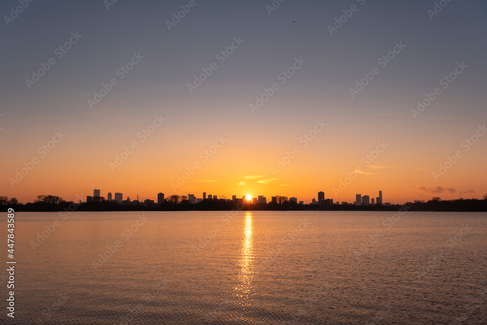 Sunset over the Rotterdam skyline as seen from Kralingse Plas (Lake Kralingen) with colorful sky reflecting