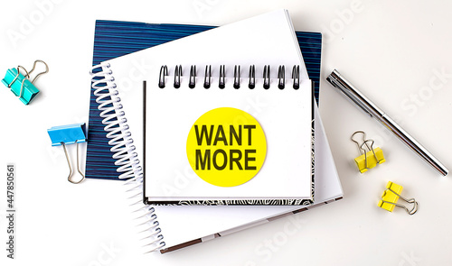 Sticker with WANT MORE text on notebooks on the white background photo