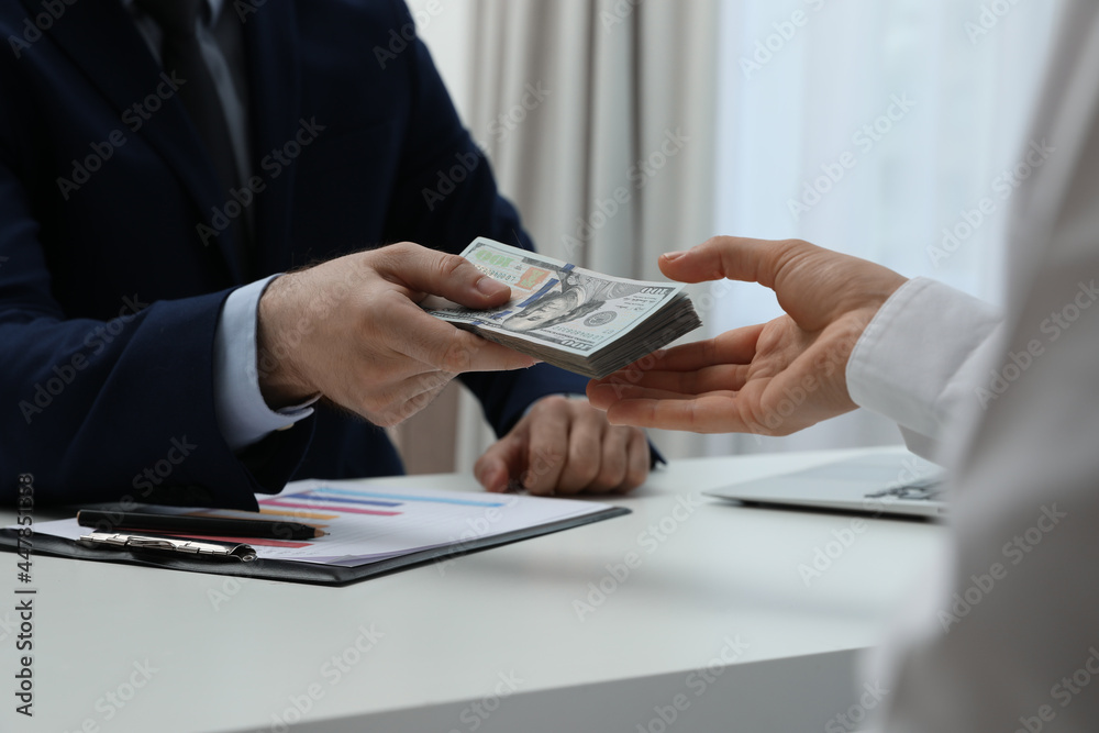 Fototapeta premium Cashier giving money to businesswoman at desk in bank, closeup