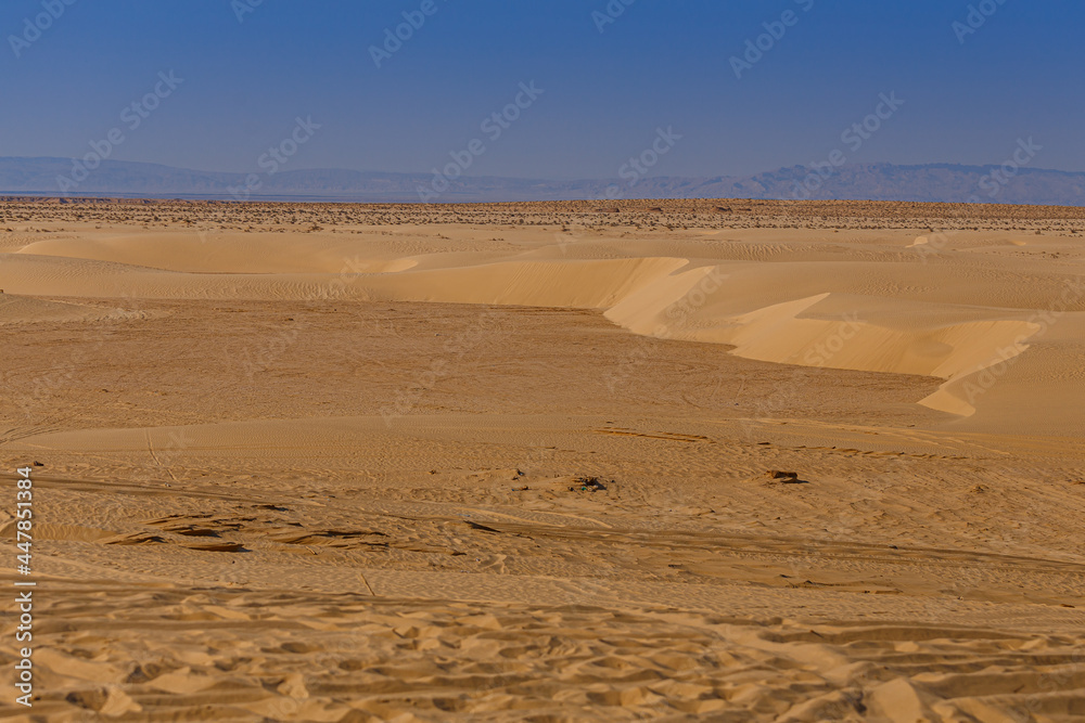 Sandy dunes on the horizon of the Sahara desert of Tunisia