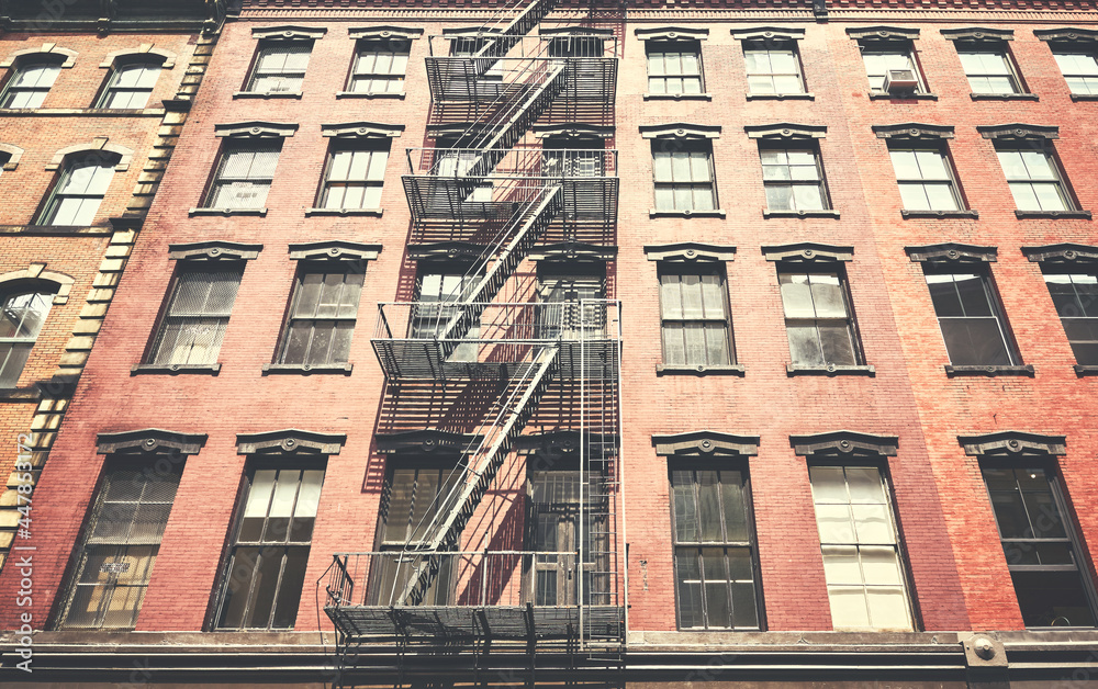 Fototapeta premium Old building with iron fire escape, color toning applied, New York City, USA.