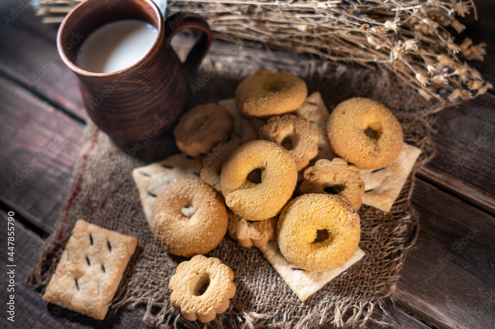 Homemade cookies with a cup of milk on a rural wooden background