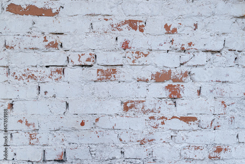 Old white brick wall with stained aged bricks. Urban background, white ruined industrial brick wall texture.