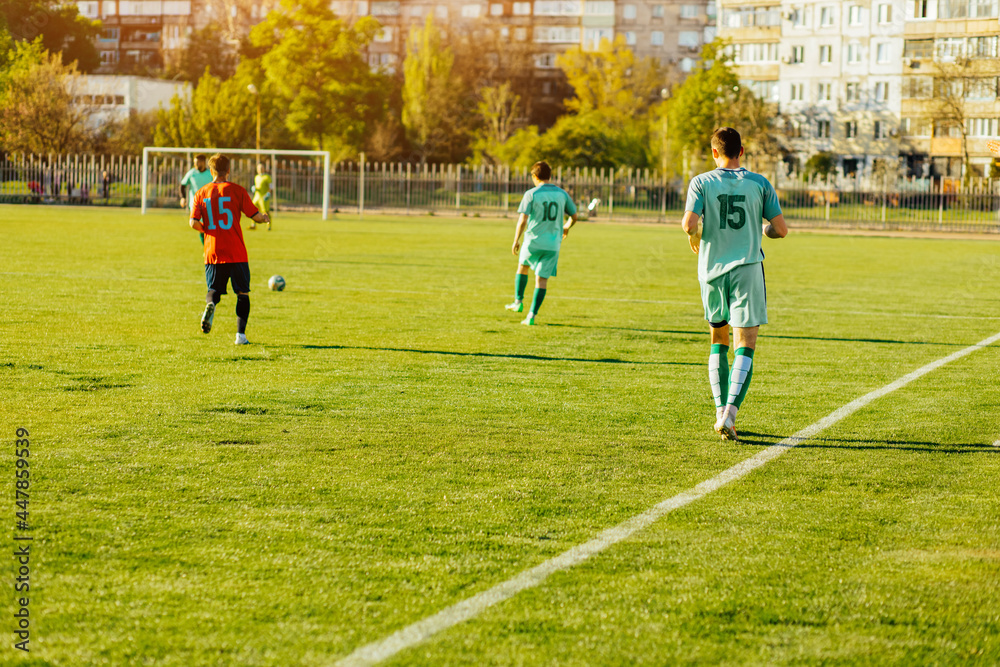 Obraz premium footballer plays a dynamic game in a professional stadium, a group of young footballers play on an open court