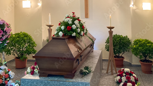 Casket prepared for funeral with flower bouquets
