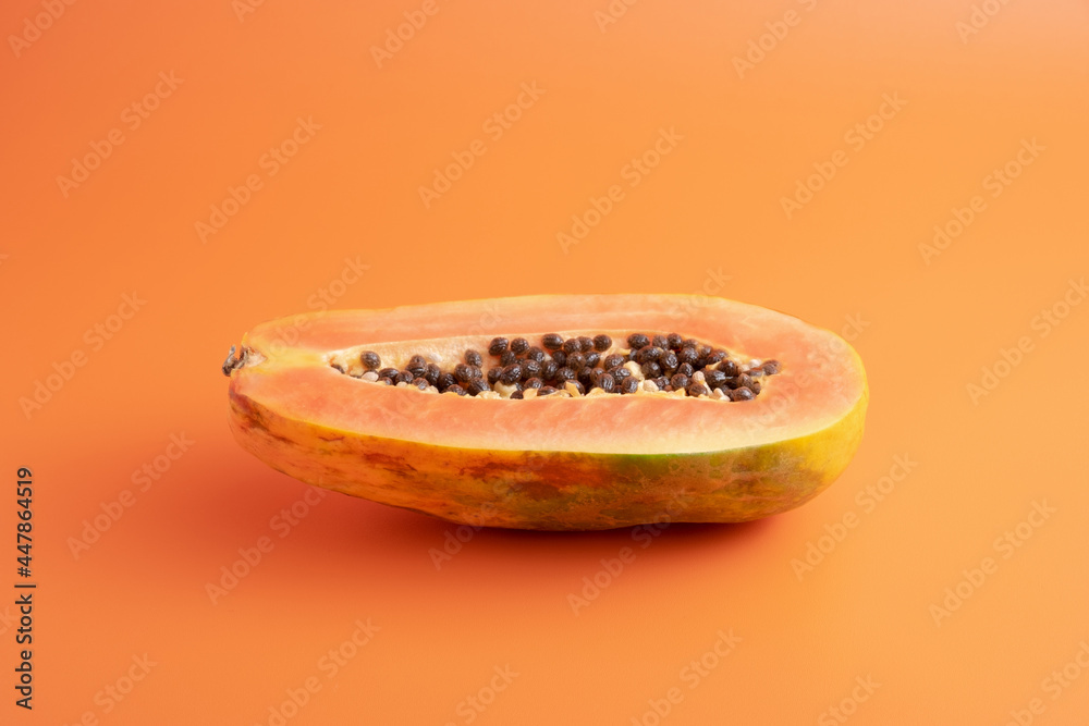 papaya fruit on orange background papaya fruit on orange background