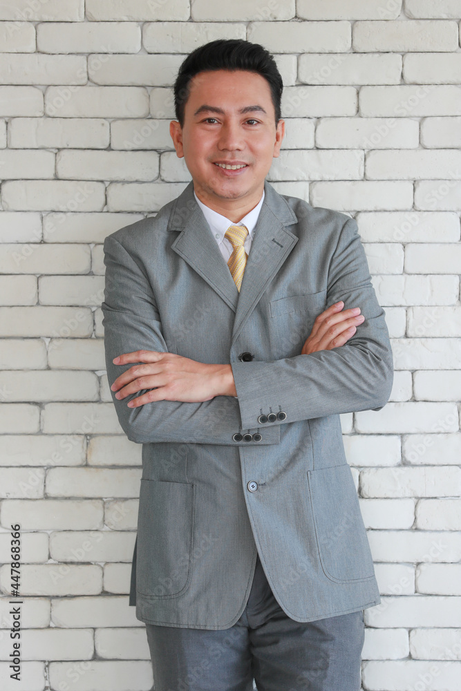 Portrait of a senior elegant looking businessman in a grey polite suit posing to camera with friendly face and self-confident Portrait of a senior elegant looking businessman in a grey polite suit posing to camera with friendly face and self-confident